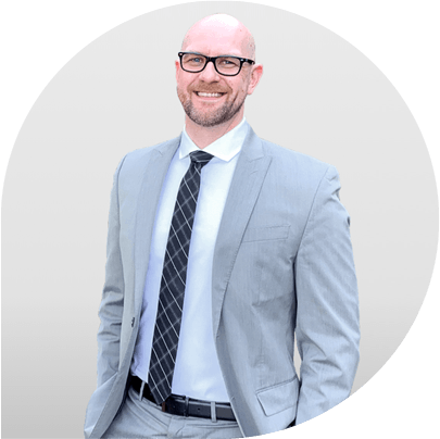 Image of Matthew Stroh wearing a grey suit with a black tie. 